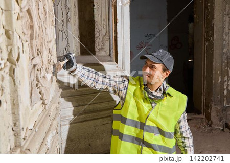 Conservator carefully removes grime from historic wall surface Conservator carefully removes grime from historic wall surface 142202741