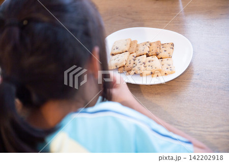 手作りの米粉チョコチップクッキーを食べる子ども 手作りの米粉チョコチップクッキーを食べる子ども 142202918