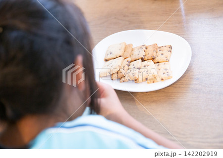 手作りの米粉チョコチップクッキーを食べる子ども 142202919