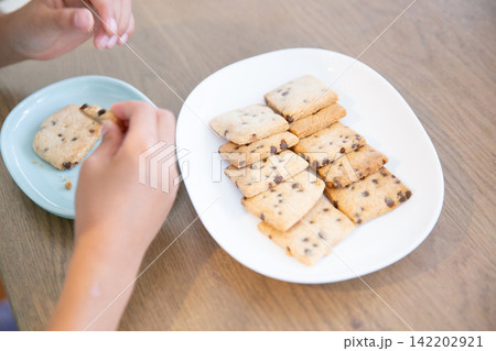 手作りの米粉チョコチップクッキーを食べる子ども 142202921