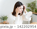 髪の毛の生え際を鏡でチェックする女性 142202954