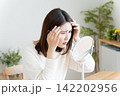 髪の毛の生え際を鏡でチェックする女性 142202956