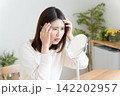 髪の毛の生え際を鏡でチェックする女性 142202957