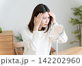 髪の毛の生え際を鏡でチェックする女性 142202960