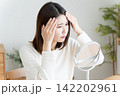 髪の毛の生え際を鏡でチェックする女性 142202961