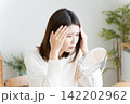 髪の毛の生え際を鏡でチェックする女性 142202962