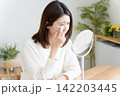 目のトラブルで鏡を見る女性 142203445
