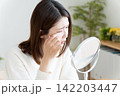 目のトラブルで鏡を見る女性 142203447