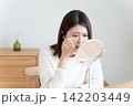 目のトラブルで鏡を見る女性 142203449