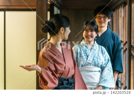 老舗の温泉旅館・高級旅館・宿坊で観光客に接客する仲居さん・女将さんと浴衣姿の夫婦 老舗の温泉旅館・高級旅館・宿坊で観光客に接客する仲居さん・女将さんと浴衣姿の夫婦 142203528