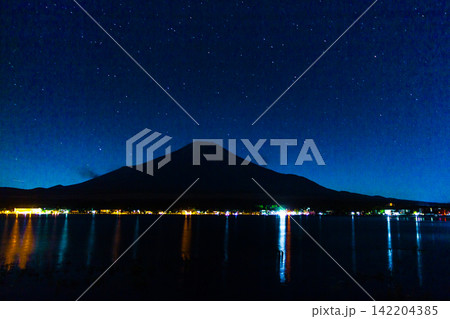Mount Fuji Silhouette Under a Vast Starry Sky With Lakeside City Reflections Mount Fuji Silhouette Under a Vast Starry Sky With Lakeside City Reflections 142204385