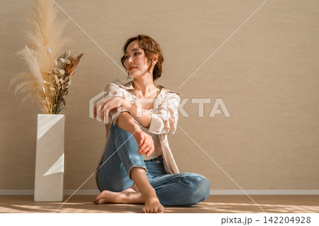 光の当たる部屋にいるデニム,ジーンズ姿の女性モデル 光の当たる部屋にいるデニム,ジーンズ姿の女性モデル 142204928