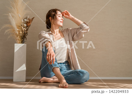 光の当たる部屋にいるデニム,ジーンズ姿の女性モデル 光の当たる部屋にいるデニム,ジーンズ姿の女性モデル 142204933