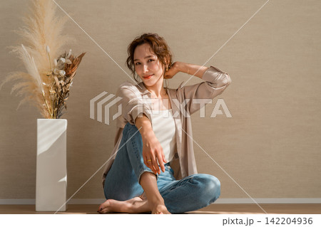 光の当たる部屋にいるデニム,ジーンズ姿の女性モデル 光の当たる部屋にいるデニム,ジーンズ姿の女性モデル 142204936