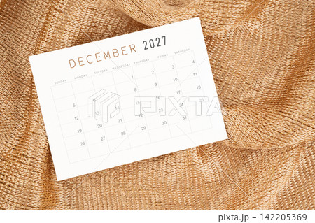 December 2027 calendar card on golden color textile. December 2027 calendar card on golden color textile. 142205369
