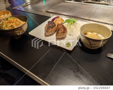 鉄板焼き店で楽しむハンバーグとガーリックライス 142208087
