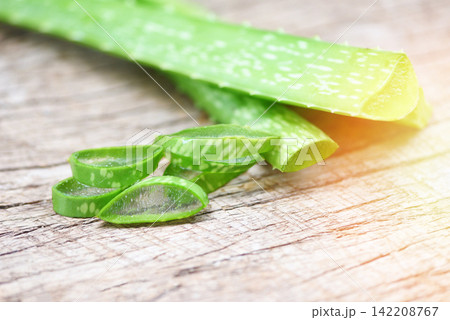aloe vera plant slice on rustic wood background - close up of fresh aloe vera leaf with gel natural herbs and herbal medicines aloe vera plant slice on rustic wood background - close up of fresh aloe vera leaf with gel natural herbs and herbal medicines 142208767