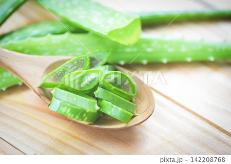 aloe vera plant slice on wood table background / close up of fresh aloe vera leaf with gel natural herbs and herbal medicines aloe vera plant slice on wood table background / close up of fresh aloe vera leaf with gel natural herbs and herbal medicines 142208768
