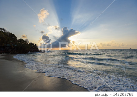 Amazing sandy tropical beach with silhouette of the beach tropical - sunrise or sunset sea dramatic sky 142208769