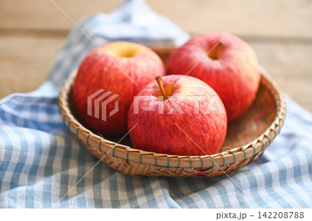 apple fruit on basket on the wooden table, ripe red apples. apple fruit on basket on the wooden table, ripe red apples. 142208788