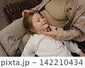 Mom and daughter share a moment on a park bench in the sunlight during a warm afternoon 142210434