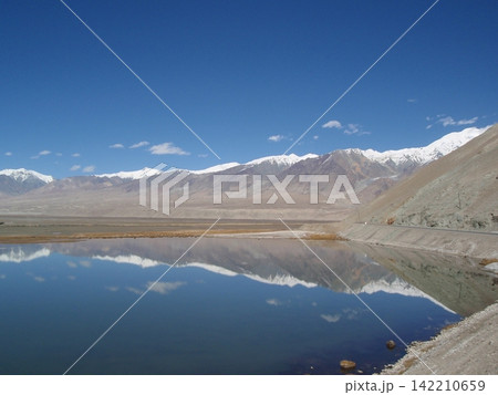 Snowy Mountain Range Reflected in Calm Alpine Lake Landscape Snowy Mountain Range Reflected in Calm Alpine Lake Landscape 142210659