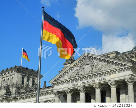 German Flag at Reichstag Building in Berlin Under Blue Sky German Flag at Reichstag Building in Berlin Under Blue Sky 142211027