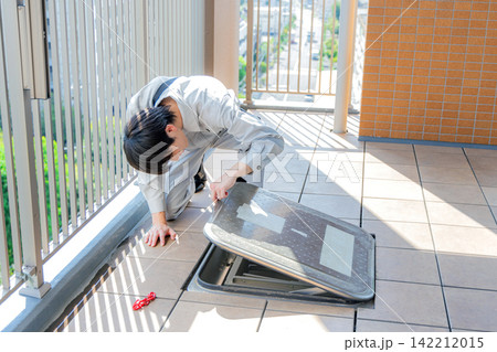 バルコニーの避難はしごを点検する作業員 バルコニーの避難はしごを点検する作業員 142212015