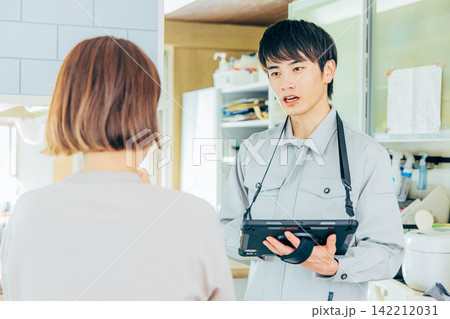 説明をする作業着を着た男性 説明をする作業着を着た男性 142212031