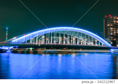青光る永代橋、スカイツリー、車と1色の船の軌跡、空と川が大きく写る東京夜景 青光る永代橋、スカイツリー、車と1色の船の軌跡、空と川が大きく写る東京夜景 142212967
