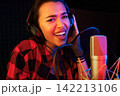 Close-up of young woman singing emotionally in a recording booth 142213106
