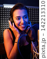 Close-up of a young singer during a recording session in a studio 142213310