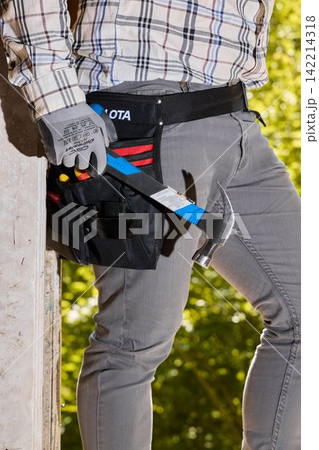 Construction worker equipped with tools and safety gear outside Construction worker equipped with tools and safety gear outside 142214318