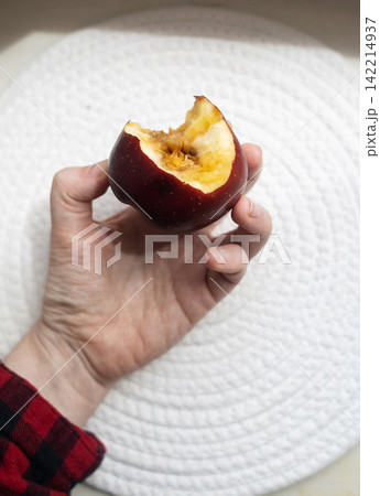 A hand holding a bitten rotten red apple showing internal browning, monilinia fungal rot, and core disease. Concept of fruit pathology and spoiled food. A hand holding a bitten rotten red apple showing internal browning, monilinia fungal rot, and core disease. Concept of fruit pathology and spoiled food. 142214937