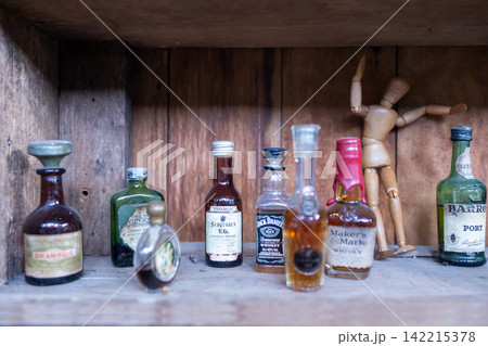 Vintage liquor bottles inside an antique showcase, focus selective Vintage liquor bottles inside an antique showcase, focus selective 142215378