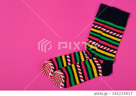 Pair of colorful striped socks on pink background with copy space. Bright casual knit hosiery flat lay top view Pair of colorful striped socks on pink background with copy space. Bright casual knit hosiery flat lay top view 142215617