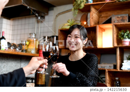 飲食店でワインで乾杯する笑顔のアジア女性 飲食店でワインで乾杯する笑顔のアジア女性 142215630
