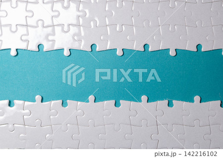 A clean white jigsaw puzzle border framing a turquoise background with empty copy space for text. High Quality Photo A clean white jigsaw puzzle border framing a turquoise background with empty copy space for text. High Quality Photo 142216102