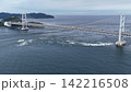 鳴門海峡に朝日が昇る鳴門大橋と迫力ある渦潮のドローン空撮写真（徳島県） 142216508
