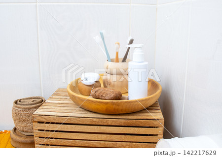 Bathroom Essentials on Wooden Tray. Dental Care and Hygiene Set with Toothbrushes Floss and Soap background Bathroom Essentials on Wooden Tray. Dental Care and Hygiene Set with Toothbrushes Floss and Soap background 142217629