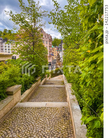 View of a pathway in Karlovy Vary surrounded by trees and buildings View of a pathway in Karlovy Vary surrounded by trees and buildings 142217753