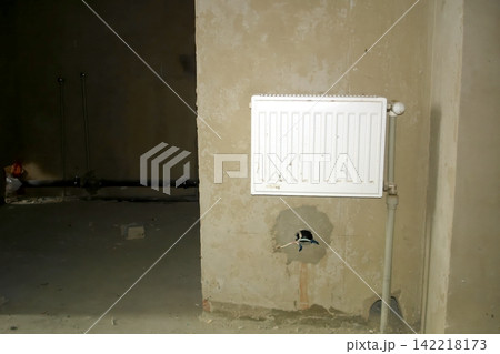 New Heating System Elements Being Installed in a Room During Rough Repairs New Heating System Elements Being Installed in a Room During Rough Repairs 142218173