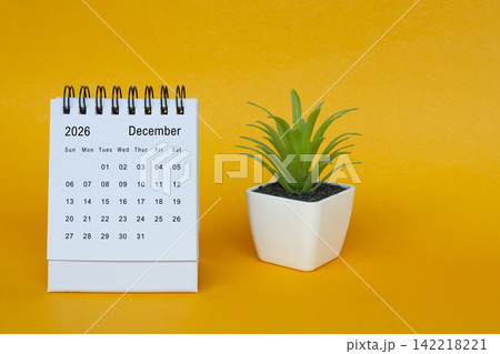Teh December 2026 desk calendar with potted plant on yellow background. Teh December 2026 desk calendar with potted plant on yellow background. 142218221