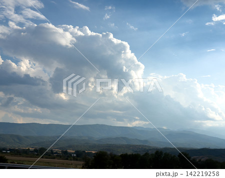 Towering White Clouds Above Distant Blue Mountain Landscape Towering White Clouds Above Distant Blue Mountain Landscape 142219258