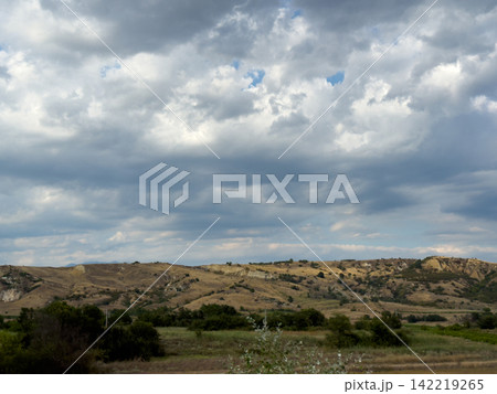 Stormy Clouds Above Farmland And Rolling Rural Hills Stormy Clouds Above Farmland And Rolling Rural Hills 142219265