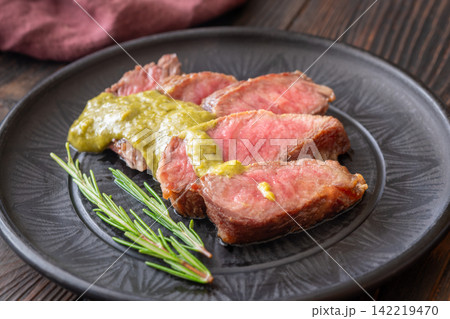 Sliced Wagyu beef steak medium rare with herb sauce rosemary gourmet presentation Sliced Wagyu beef steak medium rare with herb sauce rosemary gourmet presentation 142219470