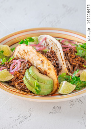 Pulled beef tacos with avocado pickled onions cilantro lime Mexican street food 142219476