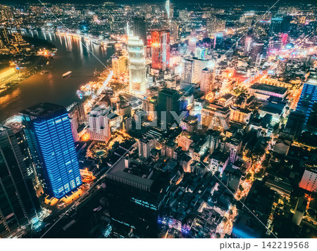 Aerial night view of Ho Chi Minh City skyline with glowing skyscrapers and neon lights, Drone panorama of Saigon downtown, illuminated towers and busy streets of vibrant city Aerial night view of Ho Chi Minh City skyline with glowing skyscrapers and neon lights, Drone panorama of Saigon downtown, illuminated towers and busy streets of vibrant city 142219568