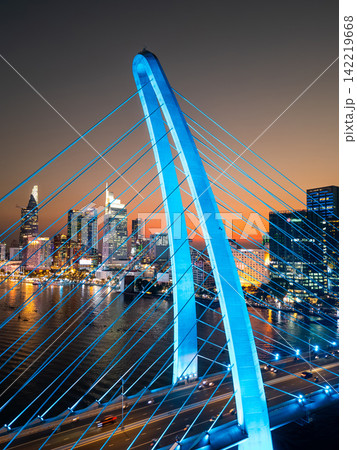 modern cable-stayed suspension bridge over Saigon river with illumination lights, financial downtown district on background, Ho Chi Minh city, Vietnam aerial drone view modern cable-stayed suspension bridge over Saigon river with illumination lights, financial downtown district on background, Ho Chi Minh city, Vietnam aerial drone view 142219668