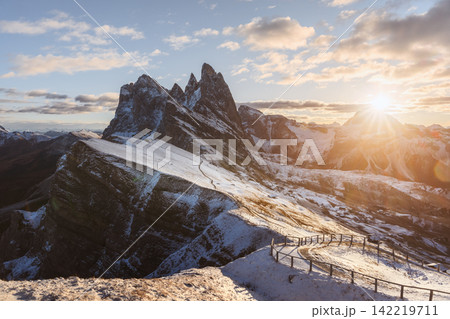 Sunstar above the snow-covered ridges of Seceda during sunrise Sunstar above the snow-covered ridges of Seceda during sunrise 142219711